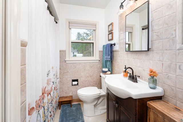 2006 Gearhart St, Duluth, MN 55811 - bathroom featuring tile walls, vanity, toilet, a shower with shower curtain, and a wainscoted wall