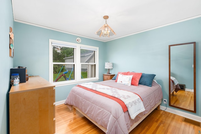 2006 Gearhart St, Duluth, MN 55811 - bedroom featuring a chandelier, baseboards, light wood-type flooring, and crown molding