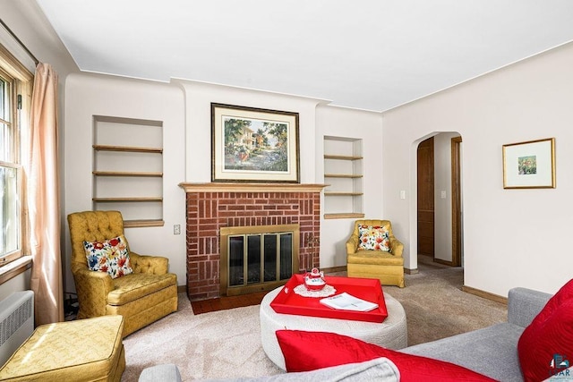 3319 E Superior St, Duluth, MN 55804 - carpeted living area with radiator heating unit, arched walkways, built in features, a fireplace, and baseboards