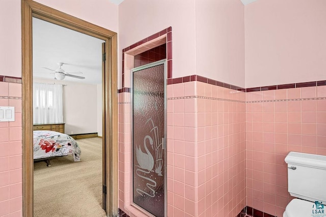 3319 E Superior St, Duluth, MN 55804 - bathroom featuring a stall shower, ceiling fan, toilet, connected bathroom, and tile walls