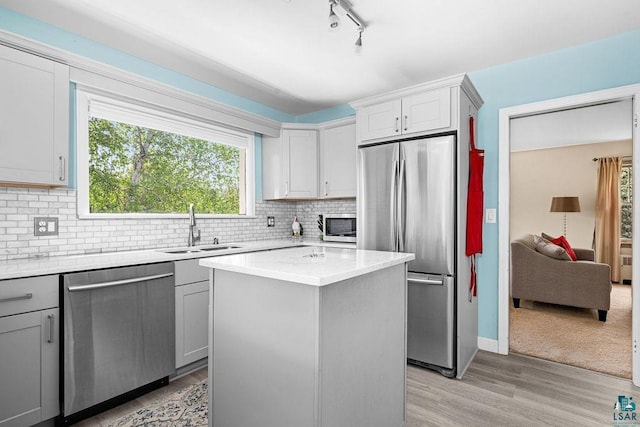 3319 E Superior St, Duluth, MN 55804 - kitchen with appliances with stainless steel finishes, a sink, rail lighting, light wood-style floors, and gray cabinets