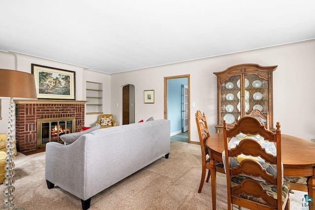 3319 E Superior St, Duluth, MN 55804 - living area featuring light carpet, arched walkways, a fireplace, and built in shelves