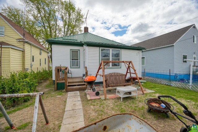 316 W 3rd Ave N, Aurora, MN 55705 - rear view of house featuring a wooden deck, a chimney, metal roof, and a fire pit