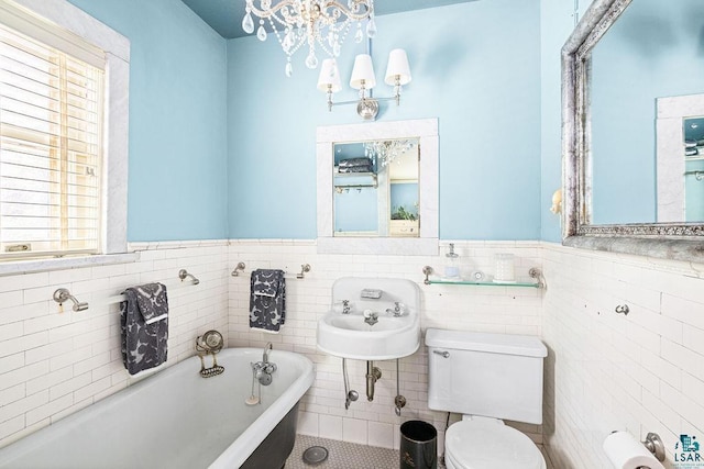 2401 E 5th St, Duluth, MN 55812 - full bathroom featuring toilet, a bath, a wainscoted wall, tile walls, and a chandelier