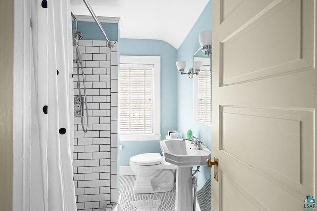 2401 E 5th St, Duluth, MN 55812 - bathroom with toilet, tiled shower, tile patterned flooring, baseboards, and vaulted ceiling