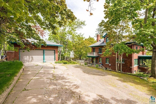 2401 E 5th St, Duluth, MN 55812 - view of front facade featuring a detached garage, a chimney, and brick siding