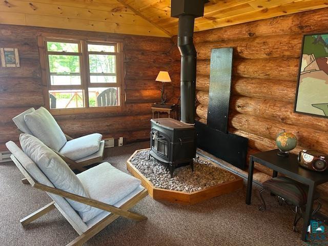 13321 Lodge Rd, Ely, MN 55731 - sitting room with a wood stove, carpet floors, log walls, and wooden ceiling