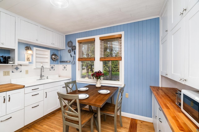 244 E 3rd St, Knife River, MN 55609 - kitchen featuring butcher block counters, light wood-style flooring, open shelves, a sink, and white cabinetry