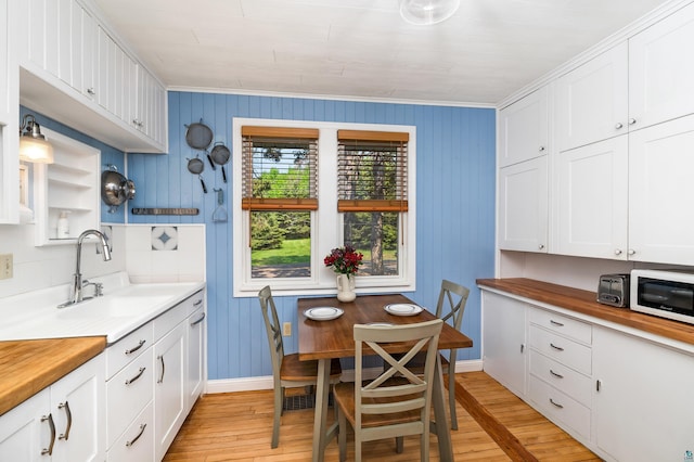 244 E 3rd St, Knife River, MN 55609 - kitchen featuring a sink, light wood-style floors, white cabinets, and crown molding