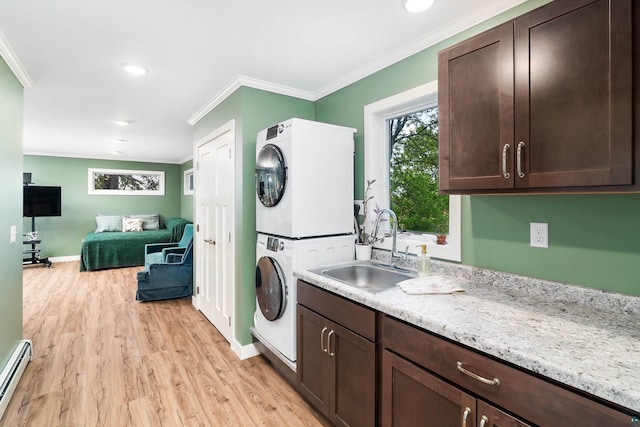 244 E 3rd St, Knife River, MN 55609 - laundry room featuring stacked washer / drying machine, light wood-style flooring, ornamental molding, a baseboard heating unit, and baseboards
