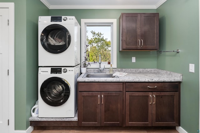 244 E 3rd St, Knife River, MN 55609 - washroom featuring estacked washer and dryer, ornamental molding, baseboards, cabinet space, and wood finished floors