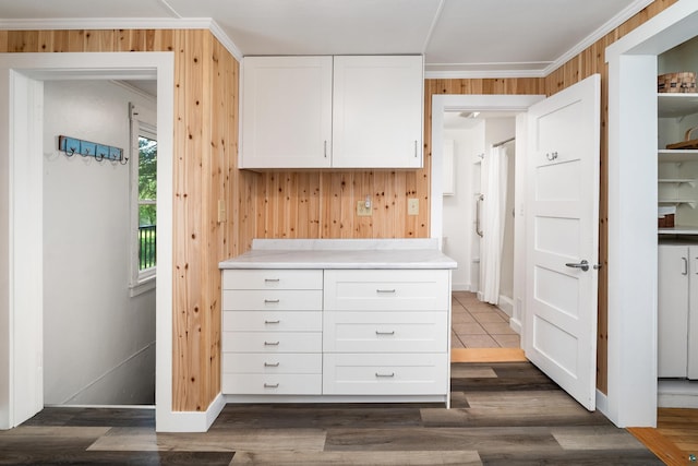 244 E 3rd St, Knife River, MN 55609 - kitchen with white cabinets, wood walls, light countertops, dark wood-type flooring, and ornamental molding