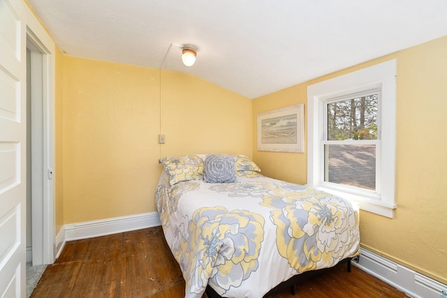 244 E 3rd St, Knife River, MN 55609 - bedroom with wood finished floors, a baseboard heating unit, baseboards, and lofted ceiling