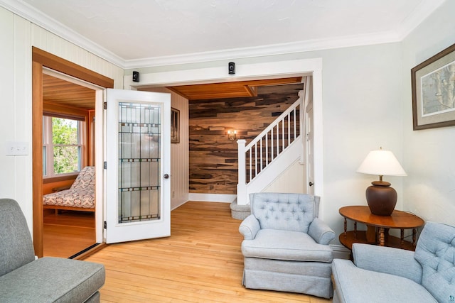 244 E 3rd St, Knife River, MN 55609 - living area with wood walls, light wood-type flooring, stairway, ornamental molding, and baseboards