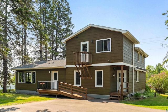 244 E 3rd St, Knife River, MN 55609 - view of front of house featuring a balcony and a front lawn
