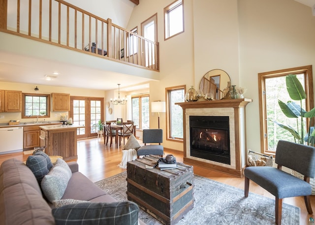 6220 N Tischer Rd, Duluth, MN 55804 - living room with light wood-style floors, a high ceiling, a chandelier, and a glass covered fireplace