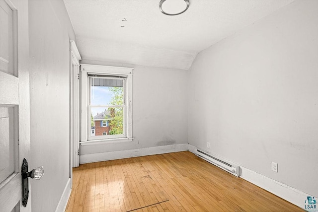 1901 E 5th St, Duluth, MN 55812 - empty room with a baseboard heating unit, vaulted ceiling, light wood-type flooring, and baseboards