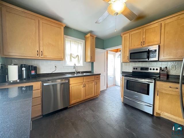 17 S 57th Ave E, Duluth, MN 55804 - kitchen with stainless steel appliances, a sink, tasteful backsplash, dark countertops, and a ceiling fan