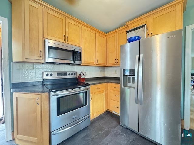 17 S 57th Ave E, Duluth, MN 55804 - kitchen featuring stainless steel appliances, dark countertops, light brown cabinets, and decorative backsplash