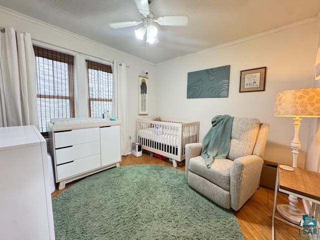 17 S 57th Ave E, Duluth, MN 55804 - bedroom with wood finished floors, ornamental molding, a crib, and a ceiling fan