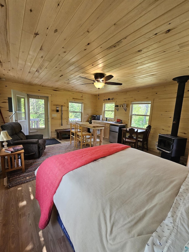 839 Loon Rd, Two Harbors, MN 55616 - bedroom featuring a wood stove, wood walls, wood ceiling, and wood finished floors