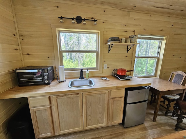 839 Loon Rd, Two Harbors, MN 55616 - kitchen with freestanding refrigerator, a sink, light brown cabinets, butcher block countertops, and wooden walls