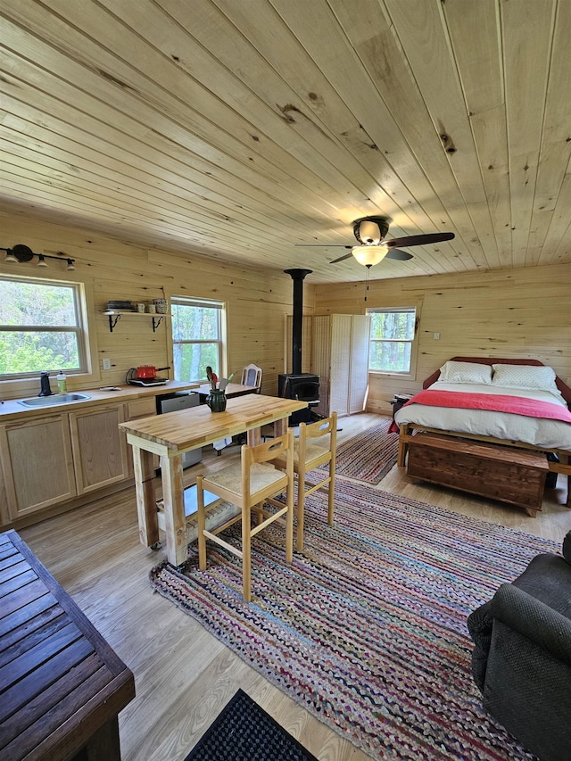 839 Loon Rd, Two Harbors, MN 55616 - dining space featuring wooden walls, a wood stove, healthy amount of natural light, light wood finished floors, and wood ceiling