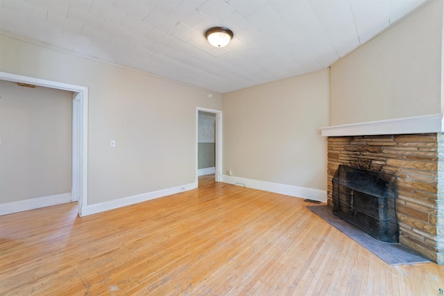 1511 E 4th St, Duluth, MN 55812 - unfurnished living room with a fireplace, light wood-style flooring, and baseboards