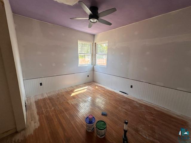 709 Summitt St, Aurora, MN 55705 - unfurnished room with wainscoting, hardwood / wood-style floors, and ceiling fan