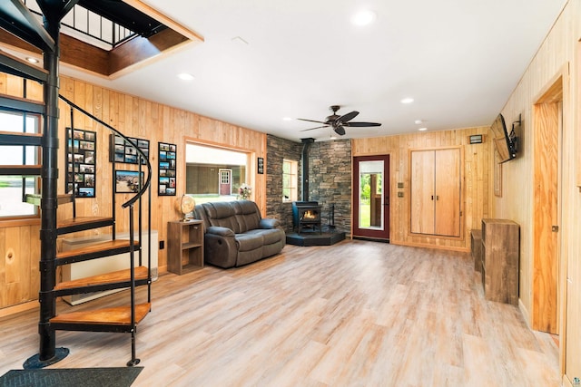 1682 Old N Shore Rd, Duluth, MN 55804 - living area featuring a wood stove, wood walls, plenty of natural light, stairs, and ceiling fan