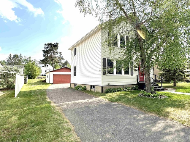 638 E James St, Ely, MN 55731 - view of property exterior featuring an outbuilding, a detached garage, and a lawn