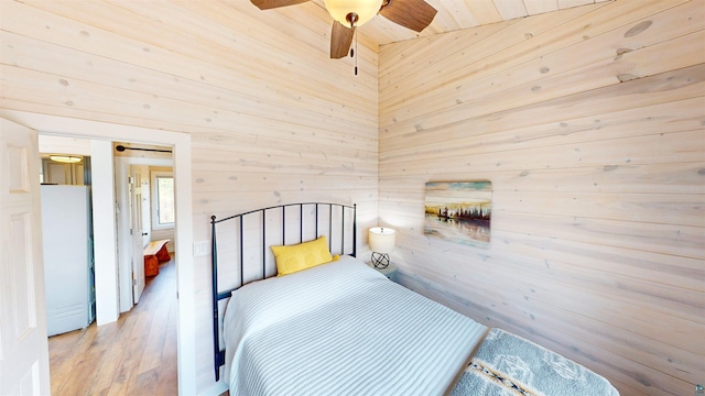 12157 Gunflint Trl, Grand Marais, MN 55604 - bedroom with freestanding refrigerator, wooden walls, and wood finished floors