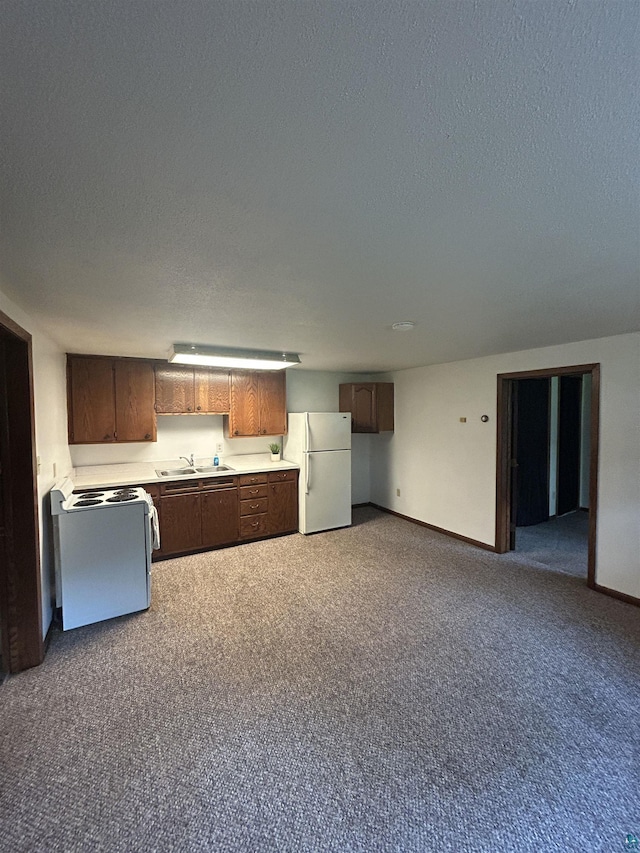 6509 Broadway St, Finlayson, MN 55735 - kitchen featuring white appliances, a textured ceiling, light countertops, carpet flooring, and open floor plan