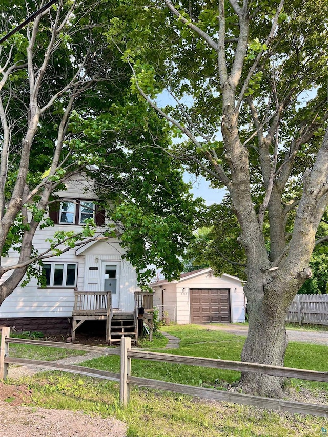6512 Raleigh St, Duluth, MN 55807 - view of property hidden behind natural elements featuring a detached garage, driveway, an outbuilding, and a deck