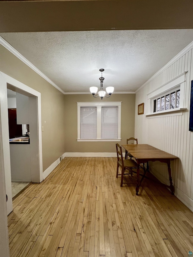 6512 Raleigh St, Duluth, MN 55807 - dining space with a chandelier, crown molding, light wood-style floors, and a textured ceiling