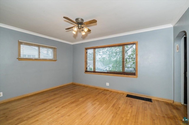 117 W Toledo St, Duluth, MN 55811 - empty room featuring a ceiling fan, arched walkways, crown molding, and wood-type flooring