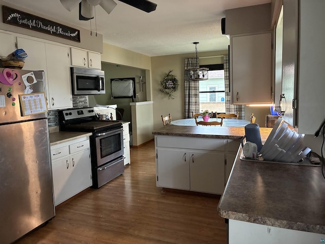 722 8th St S, Virginia, MN 55792 - kitchen with stainless steel appliances, ceiling fan, a peninsula, dark wood-style flooring, and white cabinets
