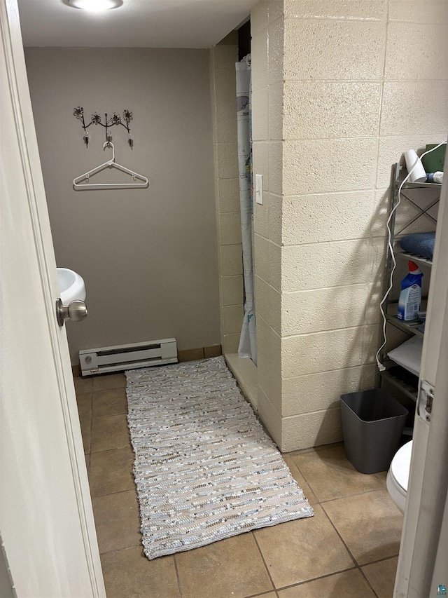 722 8th St S, Virginia, MN 55792 - bathroom with a baseboard heating unit, a stall shower, tile patterned flooring, and concrete block wall