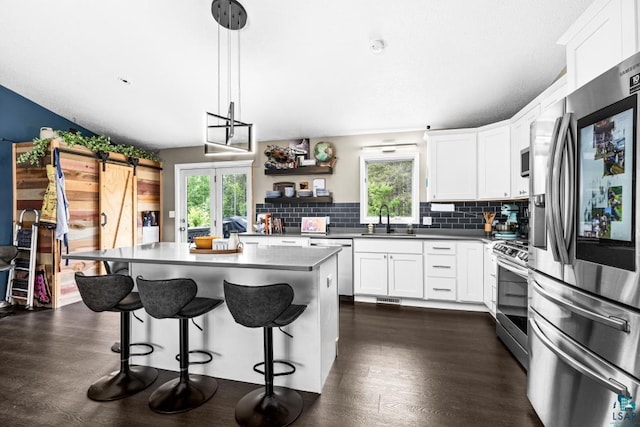 1464 Heather Ln, Cromwell, MN 55726 - kitchen featuring appliances with stainless steel finishes, healthy amount of natural light, decorative backsplash, and a breakfast bar area
