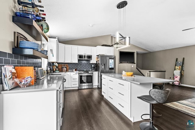 1464 Heather Ln, Cromwell, MN 55726 - kitchen with appliances with stainless steel finishes, dark wood finished floors, vaulted ceiling, backsplash, and a breakfast bar