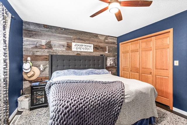 1464 Heather Ln, Cromwell, MN 55726 - bedroom featuring wooden walls, a closet, a ceiling fan, and wood finished floors