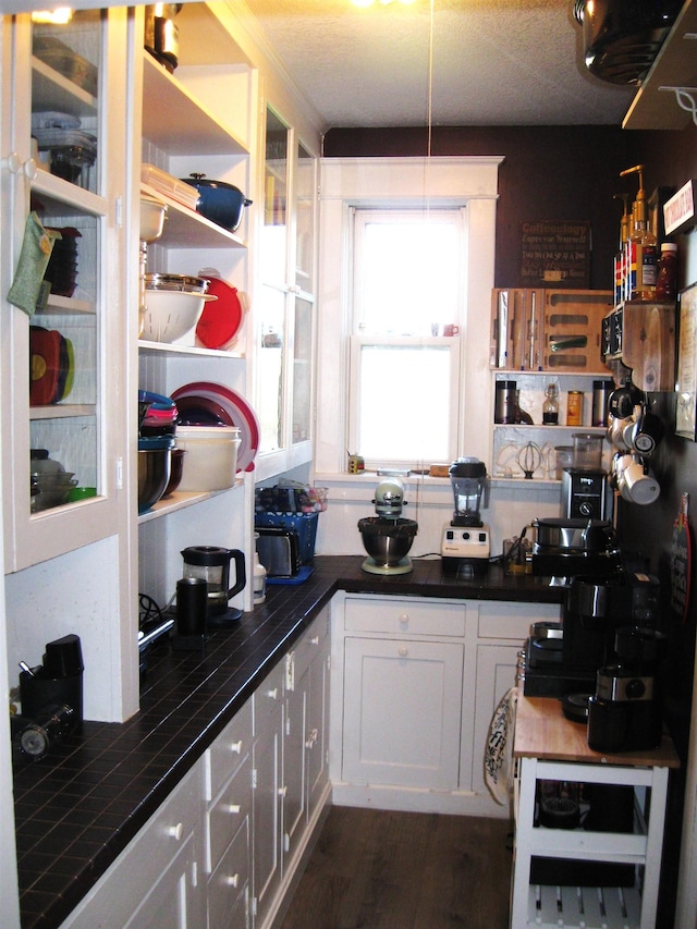 627 4th St, Proctor, MN 55810 - kitchen with open shelves, tile countertops, dark wood-style floors, and white cabinetry