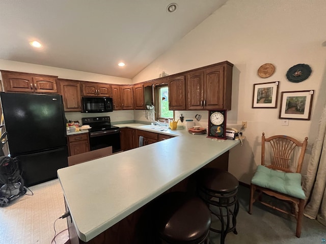 4384 Ugstad Rd, Hermantown, MN 55811 - kitchen featuring black appliances, a peninsula, a kitchen breakfast bar, lofted ceiling, and light countertops