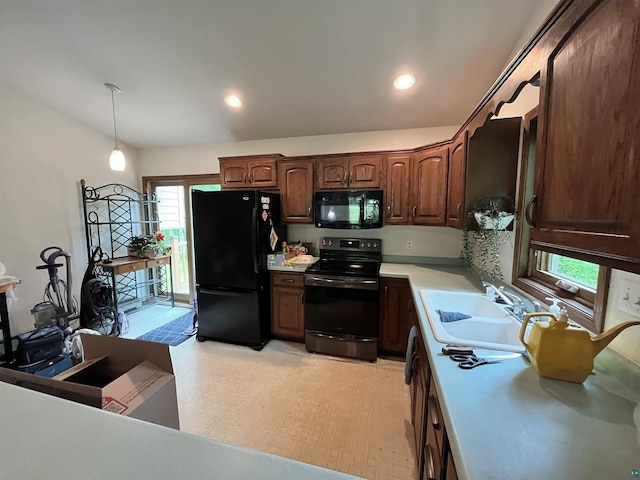 4384 Ugstad Rd, Hermantown, MN 55811 - kitchen with black appliances, light countertops, hanging light fixtures, dark brown cabinetry, and light flooring