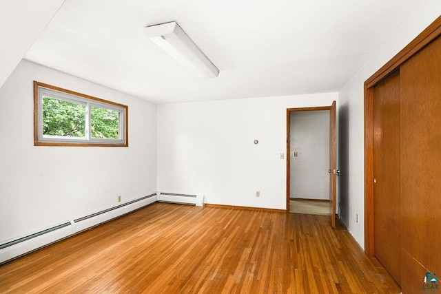 4724 E Ayers Rd, Saginaw, MN 55779 - unfurnished bedroom featuring light wood-style floors, a baseboard heating unit, a closet, and a ceiling fan