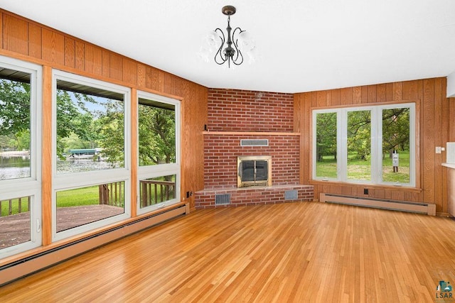 4724 E Ayers Rd, Saginaw, MN 55779 - unfurnished living room with baseboard heating, wood finished floors, wooden walls, and a fireplace