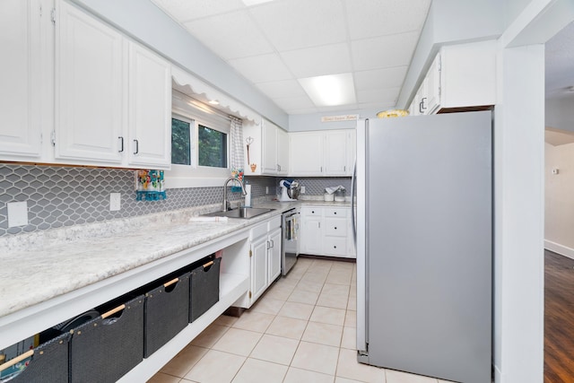 324 W Wabasha St, Duluth, MN 55803 - kitchen with freestanding refrigerator, light countertops, white cabinetry, tasteful backsplash, and a paneled ceiling