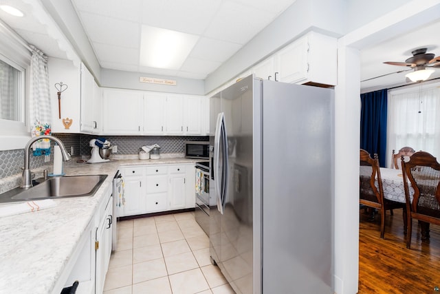 324 W Wabasha St, Duluth, MN 55803 - kitchen with appliances with stainless steel finishes, backsplash, light countertops, and a paneled ceiling