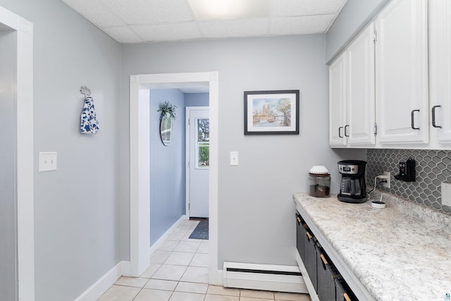 324 W Wabasha St, Duluth, MN 55803 - kitchen with baseboard heating, light countertops, decorative backsplash, light tile patterned flooring, and white cabinets