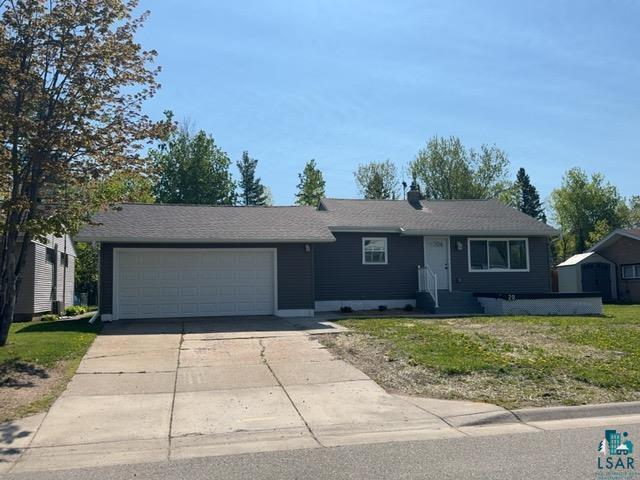 20 S Erie St, Aurora, MN 55705 - view of front facade featuring an attached garage, concrete driveway, and a front yard